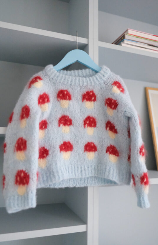 strikkeoppskrift genser med sopp. Genser jente og gutt med sopp. Enkel strikkeoppskrift barn børstet alpakka. Knitted sweater with mushroom pattern and yarn. kids mushroom sweater knitting pattern